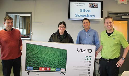 Silva Sowders is awarded a 55" HDTV by Phil Gilardi, Devon Beer and Tony Arnold